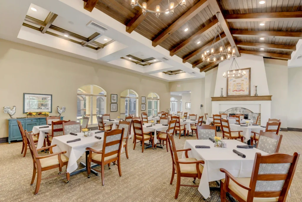 A cozy dining room at the lodge, featuring wooden tables, chairs, and large windows.