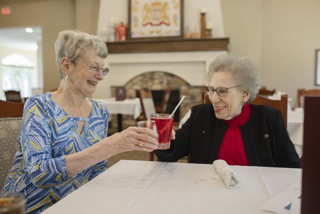 Two senior women smiling at Tuscan Gardens of Palm Coast Senior Living Community