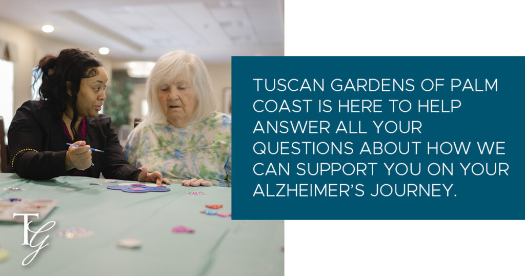 A resident in the Valeo Memory Neighborhood of Tuscan Gardens of Palm Coast enjoys an activity with one of the team members there. Text reads, "Tuscan Gardens of Palm Coast is here to help answer all your questions about how we can support you on your Alzheimer's Journey.