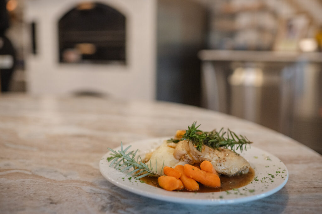 A plate featuring a serving of chicken, mashed potatoes, steamed carrots, and rich gravy, arranged appetizingly.