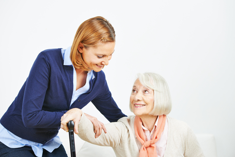 a nurse smiling with an Enhanced Assisted Living resident