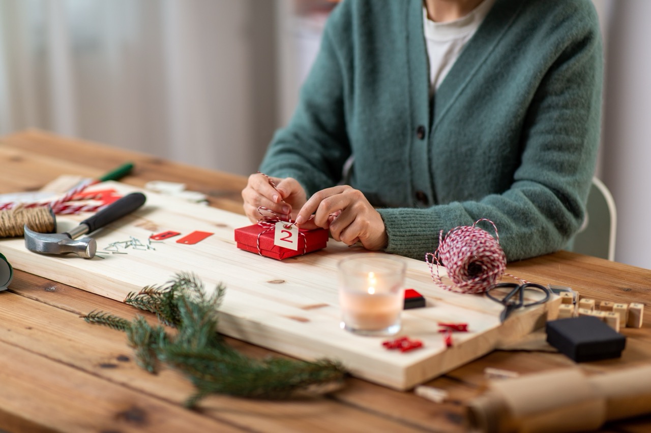 A resident at a senior living community wrapping a holiday gift for a seasonal activity. 